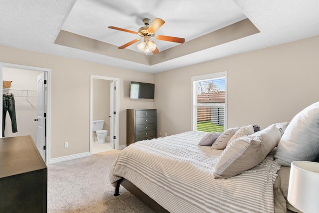 704 E Waterford Blvd, Ozark, MO 65721 - bedroom with baseboards, light carpet, a spacious closet, connected bathroom, and a raised ceiling
