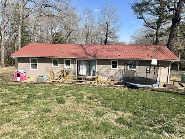 85 Peggy Ave, Mammoth Spring, AR 72554 - rear view of house featuring a trampoline, a metal roof, and a lawn