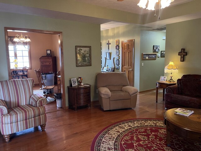1605 S Meadow Ln, Bolivar, MO 65613 - living area with ceiling fan with notable chandelier, wood finished floors, and visible vents