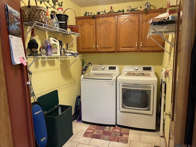 1605 S Meadow Ln, Bolivar, MO 65613 - laundry room featuring a textured ceiling, light tile patterned floors, cabinet space, and washing machine and dryer