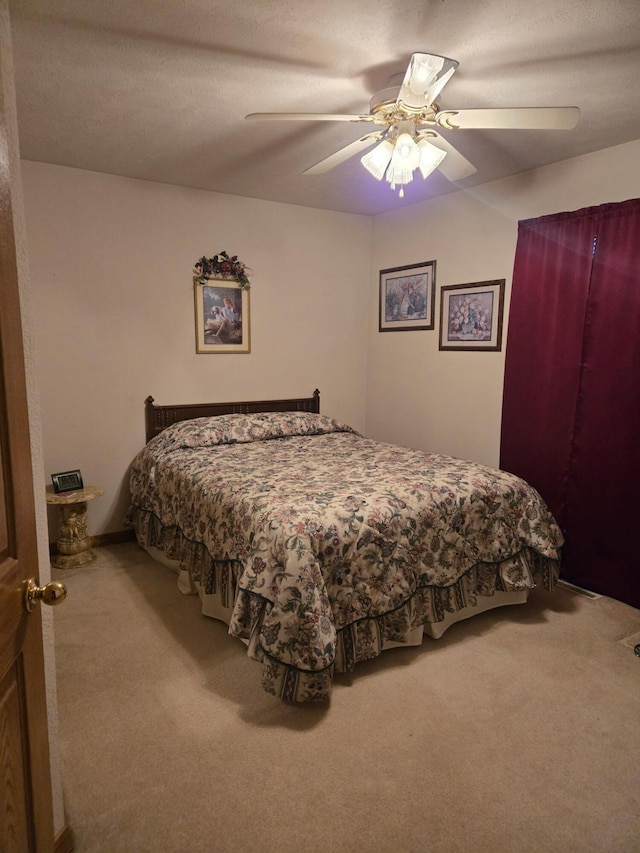 bedroom featuring ceiling fan and carpet