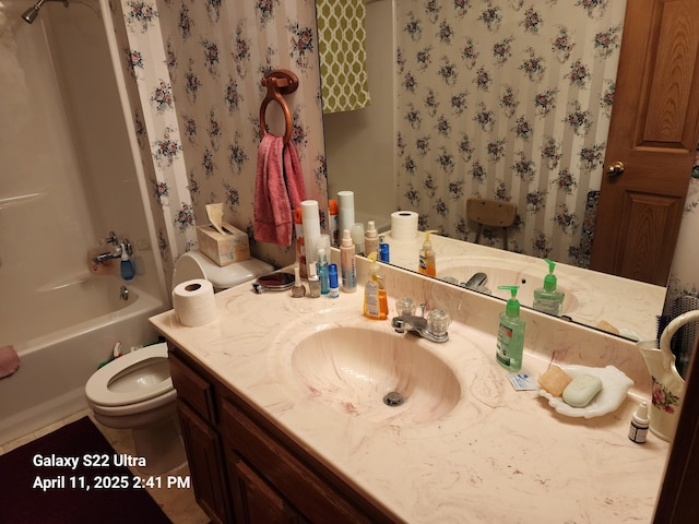full bath with bathing tub / shower combination, vanity, wallpapered walls, and toilet