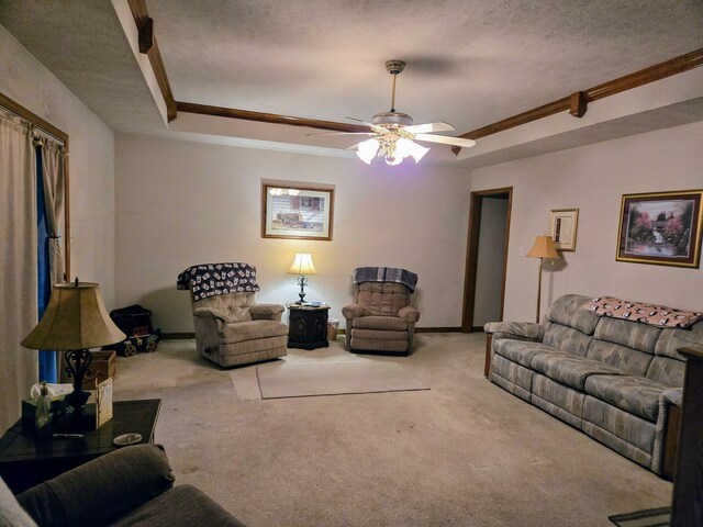 living room featuring carpet, ceiling fan, ornamental molding, and a raised ceiling