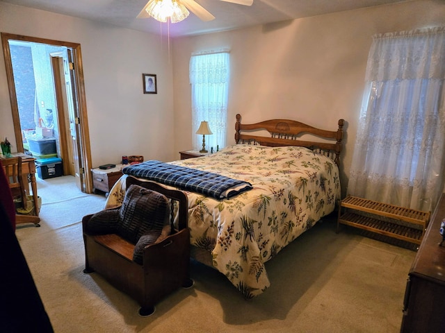 bedroom with a ceiling fan and light carpet