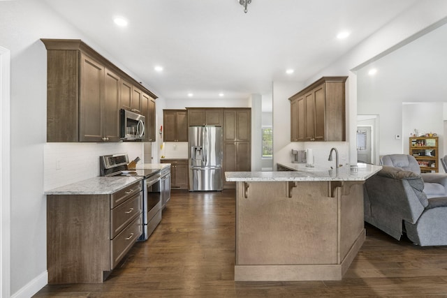 1758 W Big Meadows Ln, Nixa, MO 65714 - kitchen featuring a peninsula, tasteful backsplash, stainless steel appliances, open floor plan, and a breakfast bar area