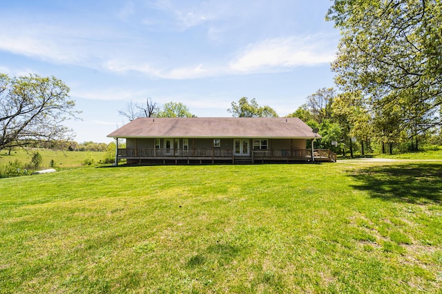 rear view of property featuring a deck and a lawn