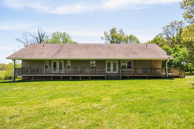 rear view of house with a yard, french doors, and a shingled roof