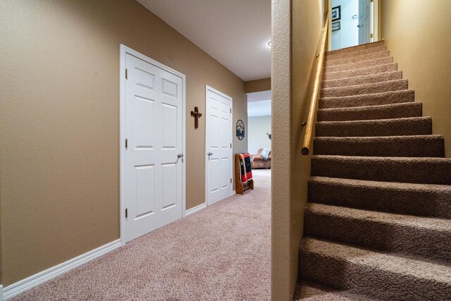 stairway featuring carpet flooring and baseboards