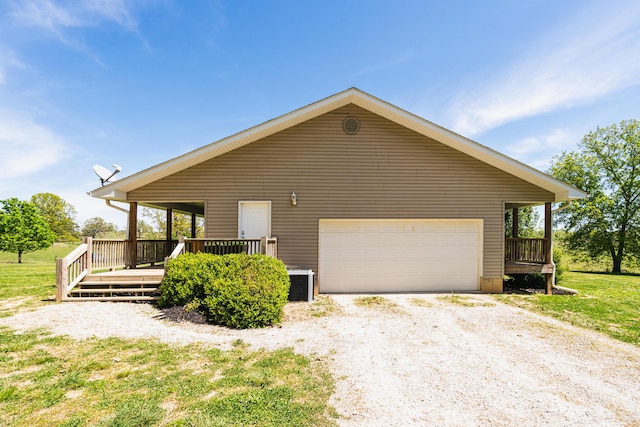 view of front of house with central AC, driveway, a wooden deck, and a garage