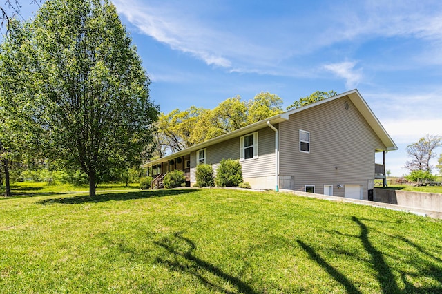 view of home's exterior featuring a yard, driveway, and an attached garage