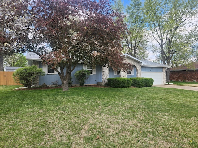 obstructed view of property featuring a front yard, an attached garage, fence, and concrete driveway