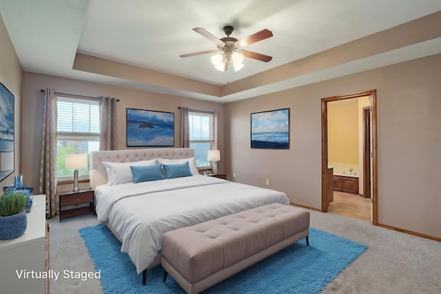 3684 Bridgewood Ave N, Springfield, MO 65803 - bedroom featuring a tray ceiling, light carpet, connected bathroom, baseboards, and ceiling fan