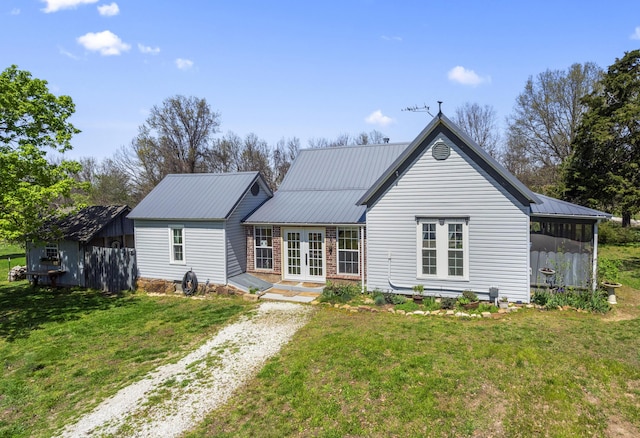 back of house featuring a yard, french doors, a sunroom, and driveway