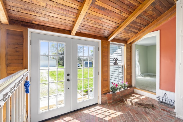 doorway with brick floor, vaulted ceiling with beams, french doors, and wooden ceiling