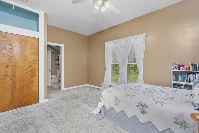 carpeted bedroom featuring ensuite bathroom, baseboards, and ceiling fan