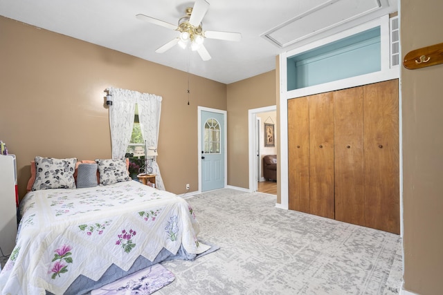 carpeted bedroom featuring baseboards, a closet, attic access, and ceiling fan