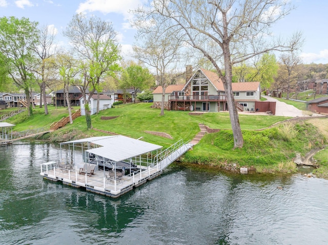 dock area with boat lift, a yard, and a water view