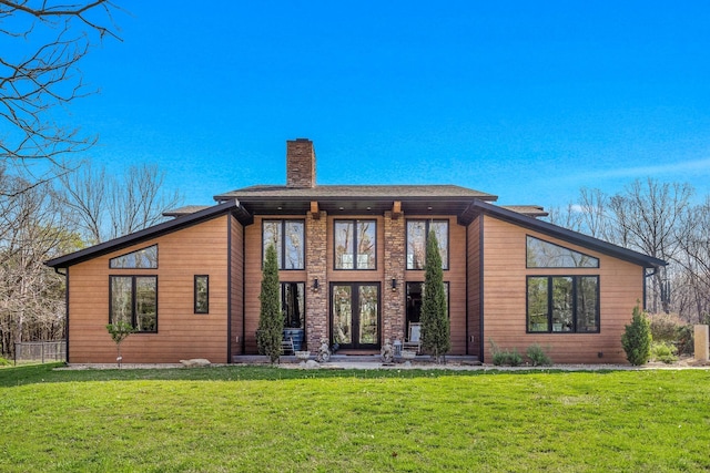 back of property featuring french doors, a yard, and a chimney