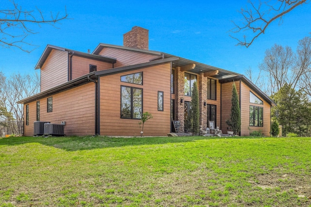 view of home's exterior featuring a chimney, central AC, and a lawn