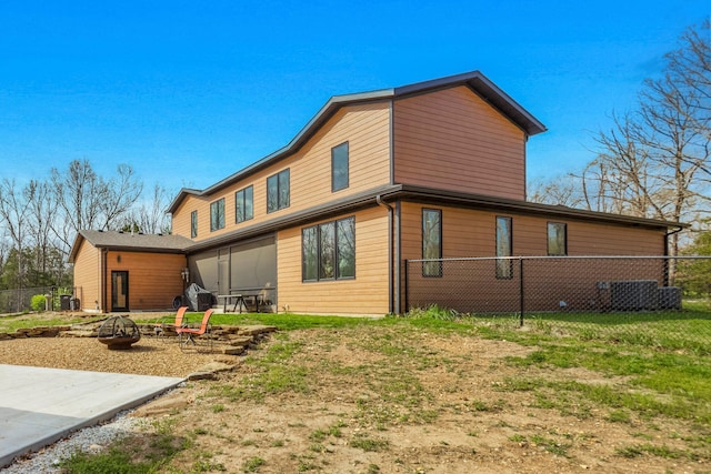 back of house featuring a fire pit, fence, a patio area, and cooling unit