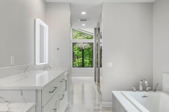 full bath featuring a bath, vanity, and marble finish floors