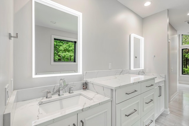 full bathroom featuring baseboards, vanity, and recessed lighting