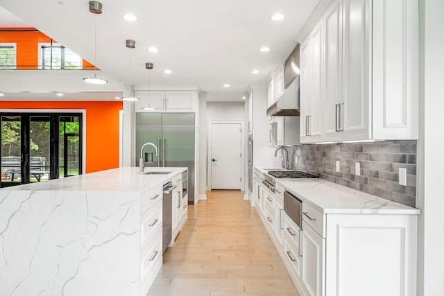 kitchen with appliances with stainless steel finishes, recessed lighting, plenty of natural light, and white cabinetry