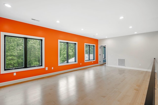 unfurnished living room featuring healthy amount of natural light, recessed lighting, light wood-style flooring, and baseboards