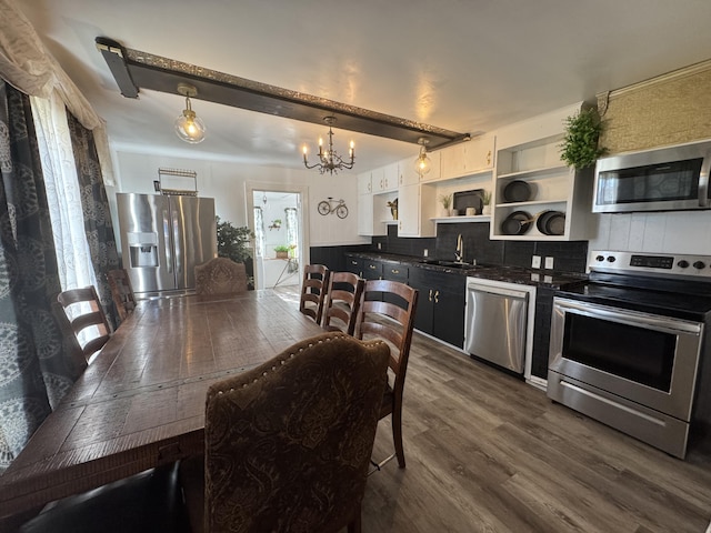 509 S Mansfield Rd, Ava, MO 65608 - kitchen featuring open shelves, an inviting chandelier, appliances with stainless steel finishes, dark wood-style floors, and backsplash