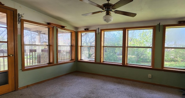 unfurnished sunroom with baseboards, carpet floors, and vaulted ceiling