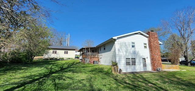 rear view of house with a lawn and a chimney
