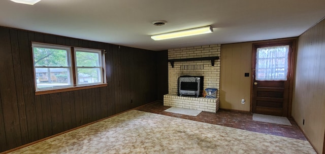unfurnished living room with wood walls and carpet flooring