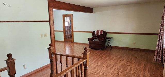 living area with baseboards and wood finished floors
