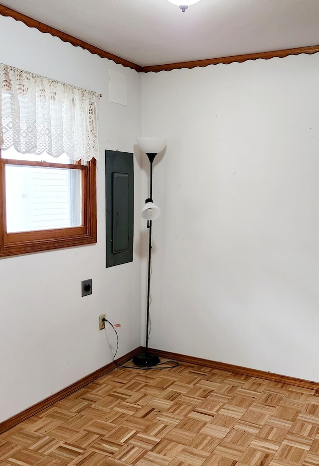 spare room featuring baseboards and electric panel