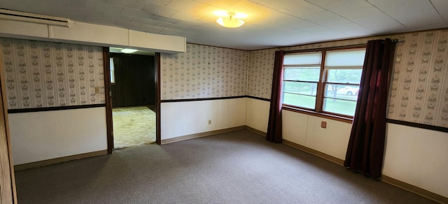 unfurnished room featuring baseboards, wallpapered walls, and wainscoting
