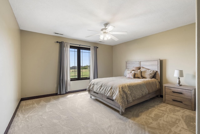 bedroom featuring light carpet, ceiling fan, baseboards, and visible vents