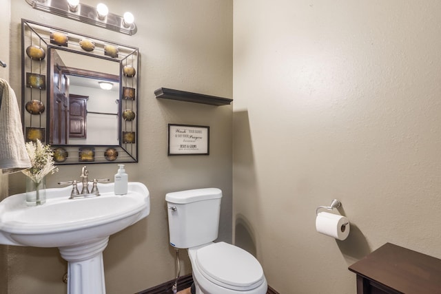bathroom with toilet and baseboards