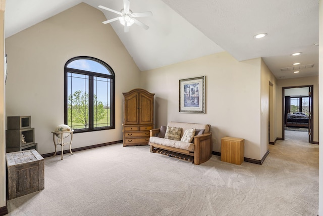 sitting room featuring baseboards, a ceiling fan, and light colored carpet