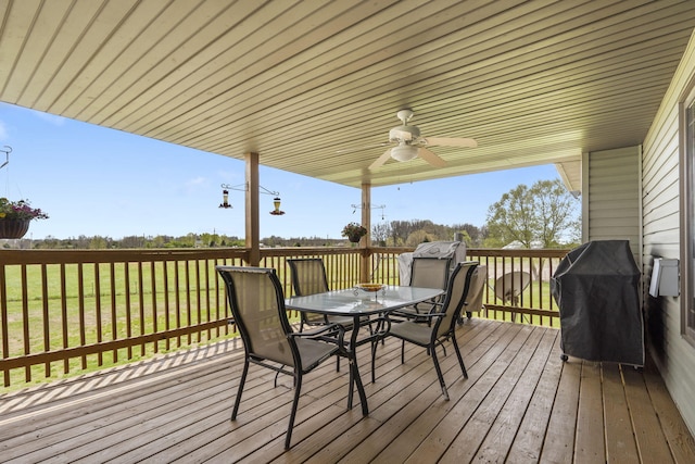 deck featuring outdoor dining space, a ceiling fan, and area for grilling