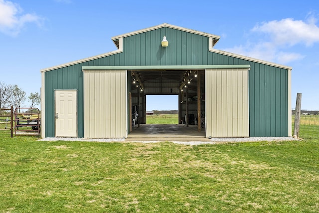 view of pole building with a yard, fence, and driveway