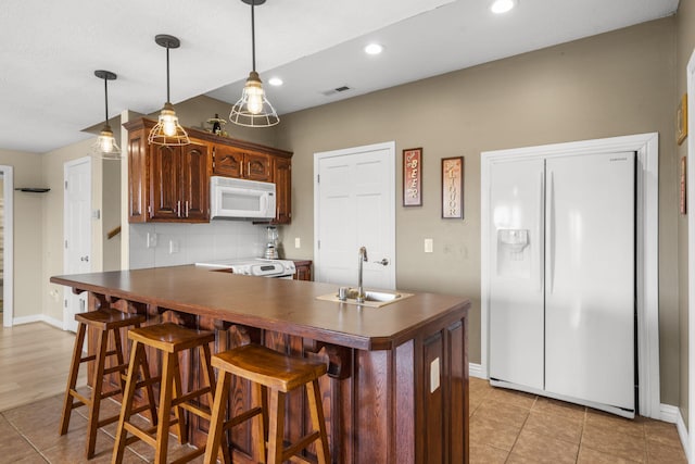 kitchen featuring white appliances, visible vents, recessed lighting, a sink, and dark countertops