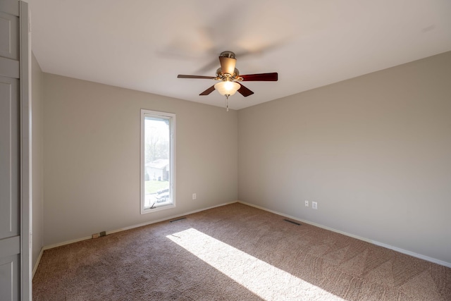 empty room with visible vents, baseboards, a ceiling fan, and carpet flooring