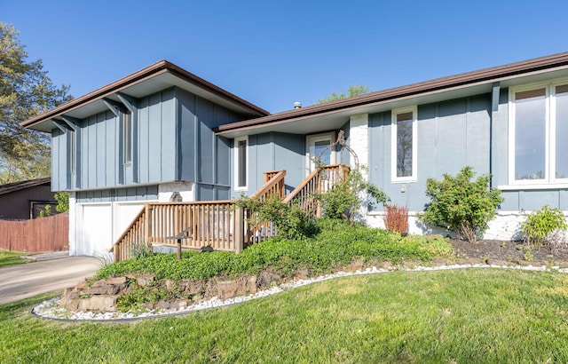 exterior space with concrete driveway, a yard, board and batten siding, and a garage