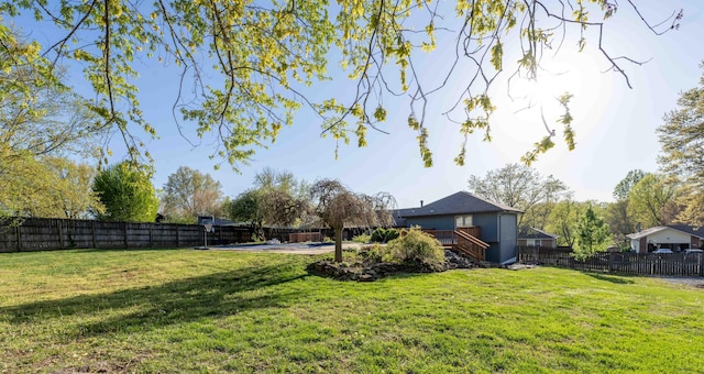 view of yard with a fenced backyard, a deck, and stairs