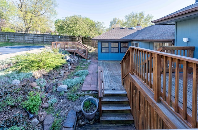 wooden terrace featuring a fenced backyard and stairway