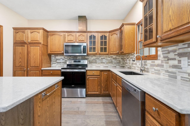 170 Oakridge Ave, Branson, MO 65616 - kitchen with appliances with stainless steel finishes, a sink, brown cabinets, and tasteful backsplash