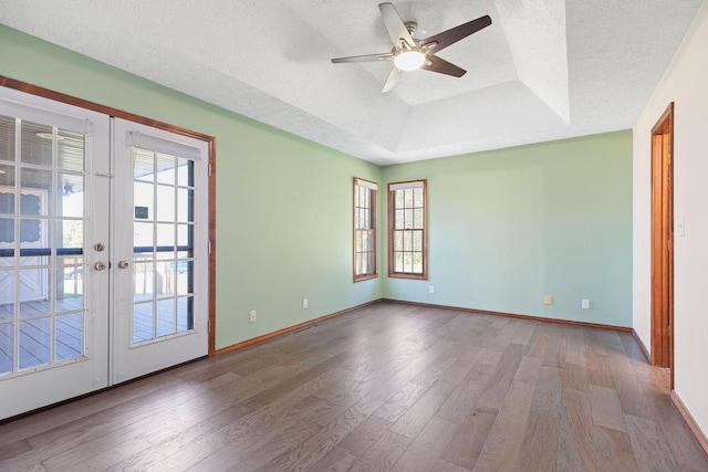 170 Oakridge Ave, Branson, MO 65616 - empty room with a raised ceiling, healthy amount of natural light, wood finished floors, a textured ceiling, and french doors