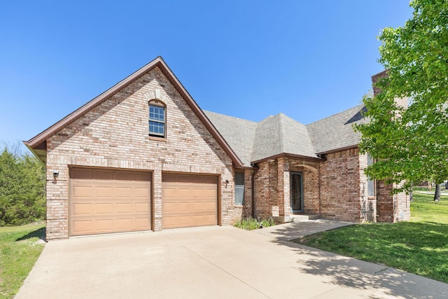 170 Oakridge Ave, Branson, MO 65616 - view of front facade featuring driveway, brick siding, a front yard, roof with shingles, and an attached garage