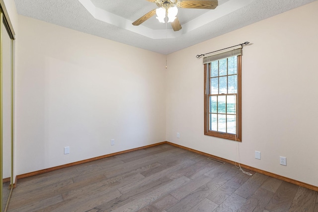 170 Oakridge Ave, Branson, MO 65616 - empty room featuring wood finished floors, a raised ceiling, baseboards, and a ceiling fan