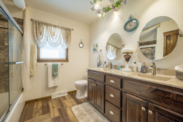 940 Industrial Dr, Neosho, MO 64850 - full bath featuring wood finished floors, double vanity, toilet, enclosed tub / shower combo, and baseboards
